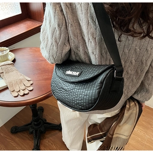 Detail of the black quilted texture and suncela logo on this stylish saddle crossbody bag