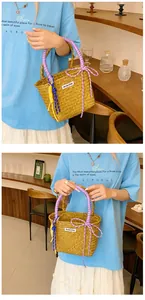 Close-up of straw bucket bag featuring purple braided handles and decorative knots