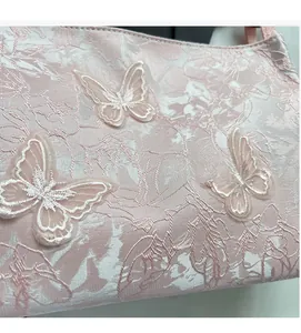 Gros plan du tissu jacquard rose avec broderie papillon 3D délicate et fine