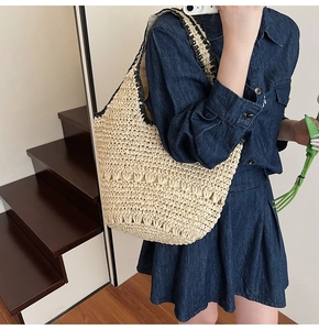 Detail of hand-woven straw shoulder bag featuring a hollow design for beach vacations