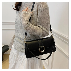 Gros plan d'un sac bandoulière en cuir noir avec détail de boucle en D doré élégant