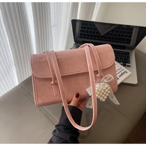 Detail of pink pleated shoulder bag with heart pearl charm and lace bow decoration