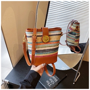 Close-up of a multicolor woven bucket bag featuring brown faux leather trim and golden lock