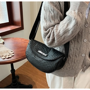 Detail of black pleated nylon saddle bag showing vertical quilting and wide strap