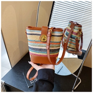 Detail of colorful striped woven bucket bag with leather trim and gold twist-lock closure