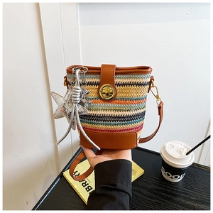 Detail of multi-color woven bucket bag with leather strap and metallic star charm
