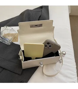 Interior view of the cream leather handbag showing space for phone and makeup accessories
