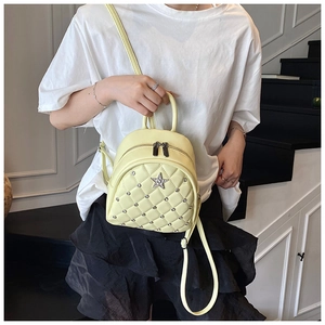 Detail of light yellow mini backpack with quilted pattern and star rivets on the front