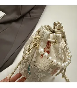 Close-up of vintage floral jacquard bucket bag with pearl handle and golden chain