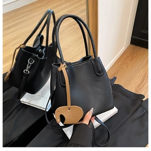 Détail du sac seau en cuir grainé noir avec un charmant pendentif en forme d'éléphant