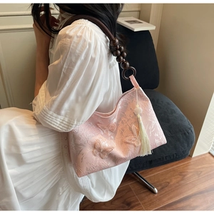 Détail du sac cabas en dentelle rose avec papillons et bandoulière en perles de bois