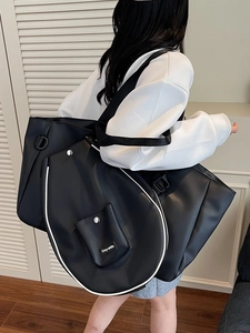 Large black shoulder tote bag for women featuring a racket-shaped front pocket design