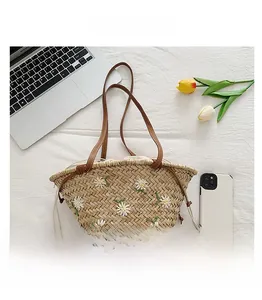 Detail showing straw bucket bag with white daisy embroidery and drawstring lining