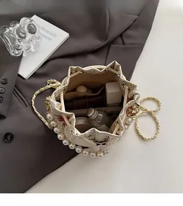 Interior view of embroidered bucket bag showing storage for lipstick and perfume