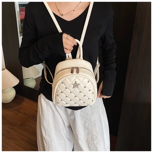Close-up of beige quilted mini backpack with sparkling star rhinestone and silver zippers