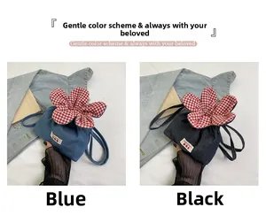 Detail of floral denim drawstring bucket bags in blue and black with letter patches