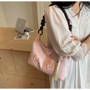 Détail d'un sac à bandoulière brodé rose avec papillons 3D et bandoulière en bois