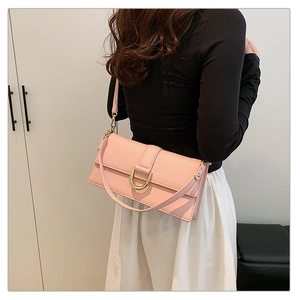 Détail du sac à bandoulière en cuir rose avec boucle en métal doré et bandoulière amovible