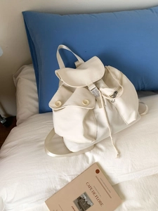 Versatile off-white canvas backpack for women featuring flap closure and dual front pockets