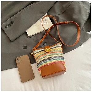 Close-up of woven bucket bag featuring colorful stripes and golden swivel lock detail