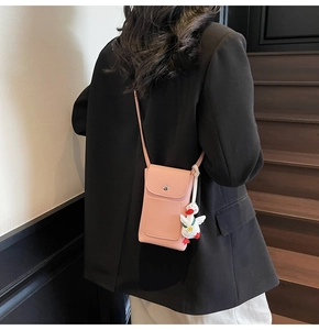 Detailed view of pink pebble leather phone crossbody bag with a cute white duck charm