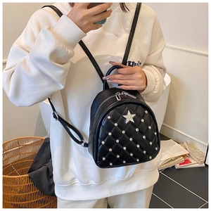 Close-up of black quilted mini backpack featuring silver rhinestones and star detail