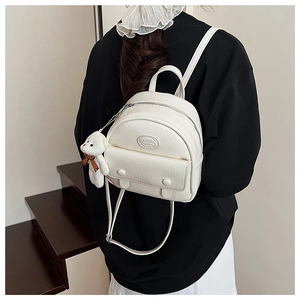 Detailed back view of mini cream white PU leather backpack with cute teddy bear charm
