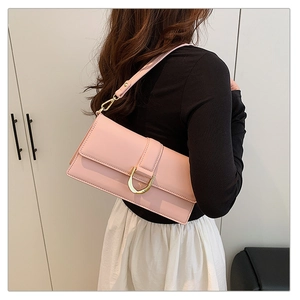 Détail du sac baguette en similicuir rose avec une boucle en métal doré en forme de U devant