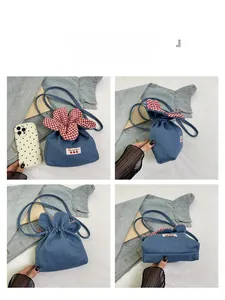 Detail view of denim bucket bag featuring floral drawstring and Yes Honey patch