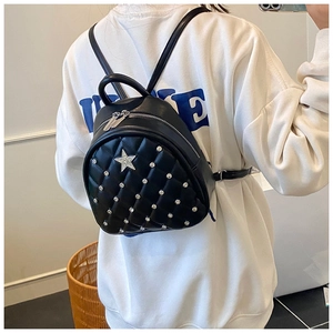 Close-up of quilted black leather mini backpack with star diamond and silver rivet details