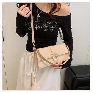 Détail du sac beige en similicuir avec boucle dorée et bandoulière réglable