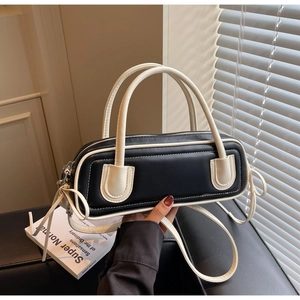 Detail of minimalist rectangular Boston bag with black body and white leather trim