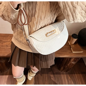 Detail of white quilted faux leather saddle bag with adjustable wide shoulder strap