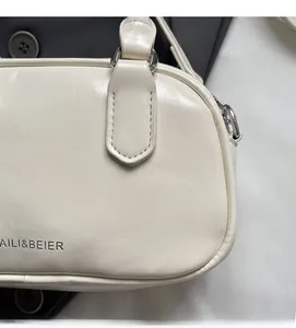 Detail of off-white leather handbag with silver hardware and embossed logo lettering