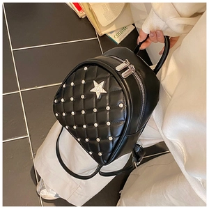 Detail of black quilted mini backpack with rhinestone embellishments and silver star icon