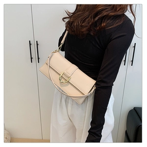 Détail d'un sac à bandoulière rectangulaire blanc crème avec boucle en D dorée
