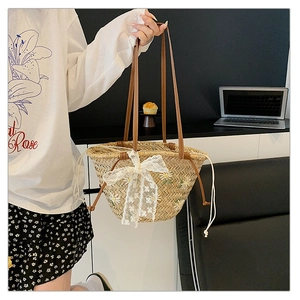 Macro view of straw bucket bag with daisy embroidery and elegant lace bow detail