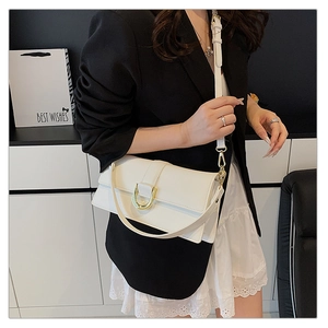 Détail du sac bandoulière blanc crème en cuir avec boucle en métal doré en forme de fer