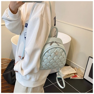 Close-up of mint green quilted mini backpack with star rhinestone and metal rivets detail