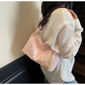 Détail du sac brodé rose avec papillons 3D et bandoulière en perles de bois