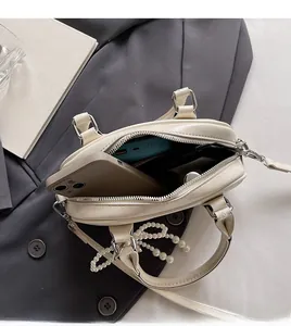 Interior view of small beige leather handbag showing capacity for phone and power bank