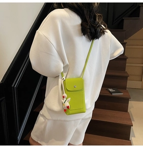 Crossbody phone bag in lime green lychee leather with a cute duck charm detail