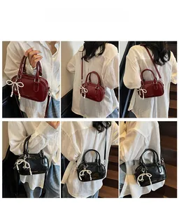 Detail of red and black retro Boston bags with pearl bow charms and adjustable straps