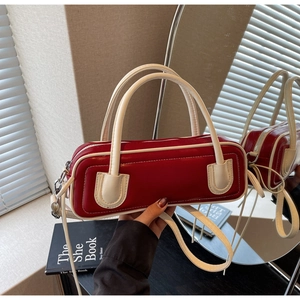 Detail of red and cream contrast bag with lychee grain texture and dual handles