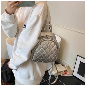 Silver quilted mini backpack with rhinestone stars shown as a crossbody on a person
