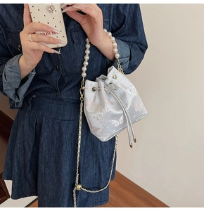 Détail du sac seau de style chinois avec anse en perles et broderie papillon