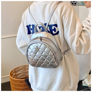 Detail of silver quilted mini backpack with star patch and metallic leather finish