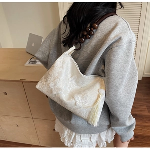 Détail du sac cabas brodé papillon blanc avec bandoulière vintage en perles de bois