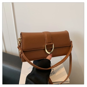 Gros plan d'un sac baguette vintage marron avec une boucle en métal doré en forme de U