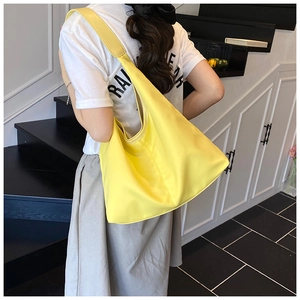 Detail of a bright yellow large capacity hobo shoulder bag for daily commuting